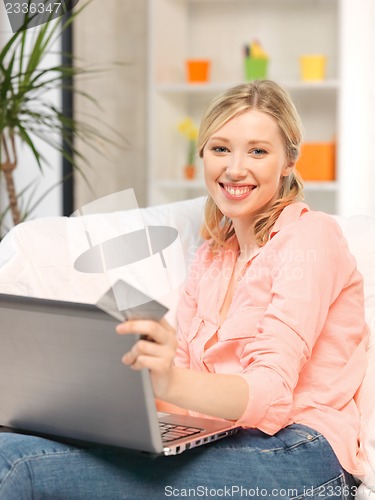 Image of happy woman with laptop computer and credit card