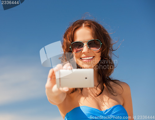 Image of happy smiling woman using phone camera