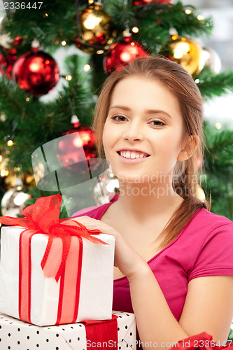 Image of happy woman with gift box and christmas tree