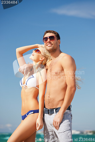 Image of happy couple in sunglasses on the beach