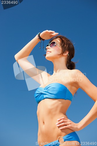 Image of happy woman in sunglasses on the beach