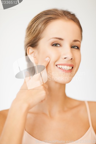 Image of beautiful woman pointing to cheek