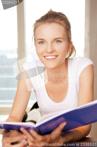 Image of happy and smiling teenage girl with big notepad