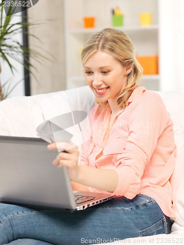 Image of happy woman with laptop computer and credit card