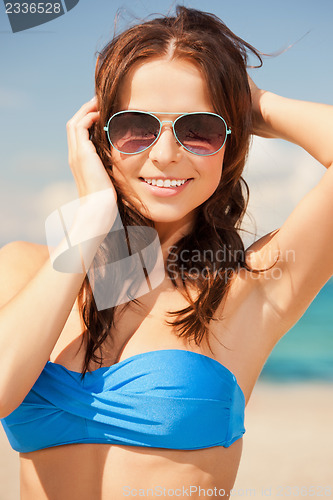 Image of happy woman in sunglasses on the beach