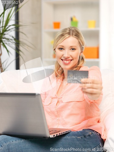 Image of happy woman with laptop computer and credit card