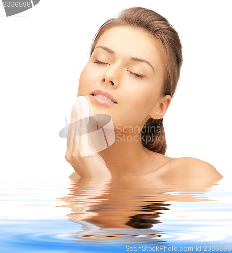 Image of beautiful woman with cotton pad in water