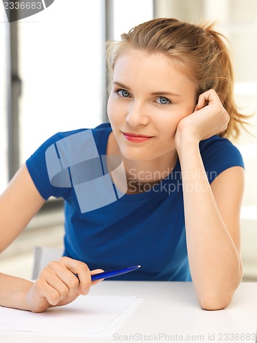 Image of happy teenage girl with pen and paper