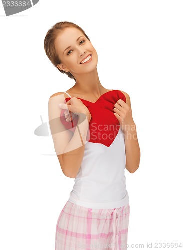 Image of happy and smiling woman with heart-shaped pillow