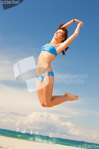 Image of happy jumping woman on the beach