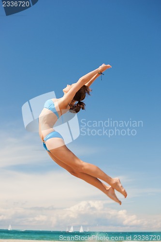Image of happy jumping woman on the beach