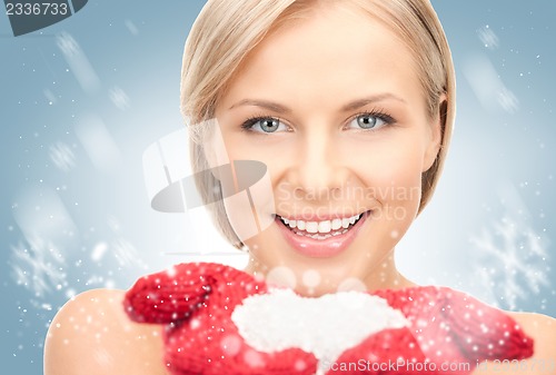 Image of beautiful woman in red mittens with snow