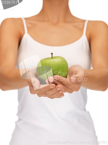 Image of female hands with green apple