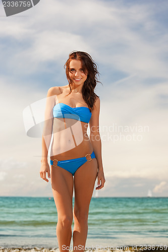 Image of happy smiling woman walking on the beach