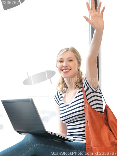 Image of happy teenage girl waving a greeting