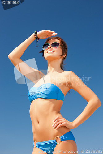 Image of happy woman in sunglasses on the beach