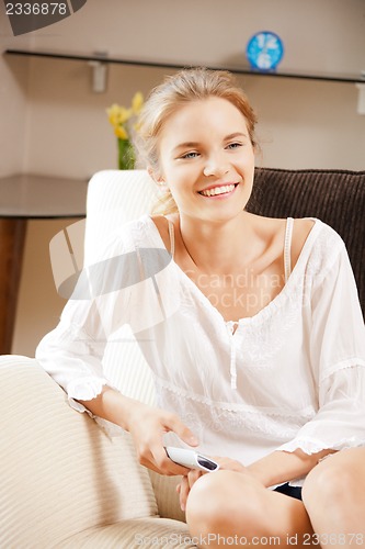 Image of happy teenage girl with TV remote