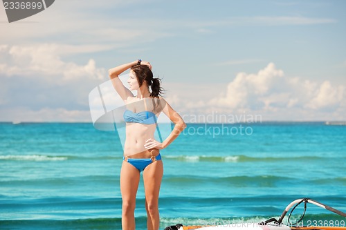 Image of happy woman with wind surf on the beach