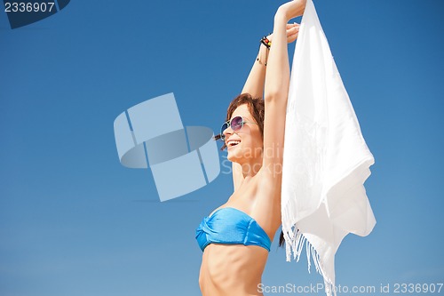 Image of happy woman with white sarong on the beach