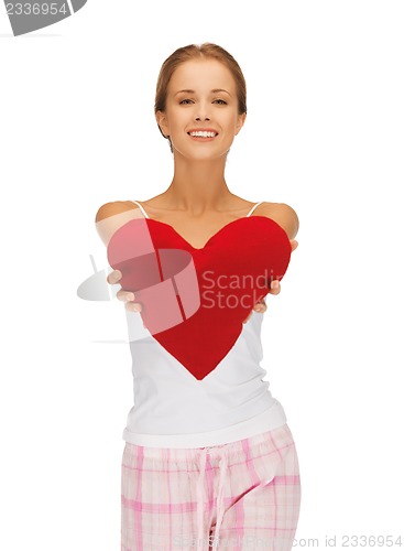 Image of happy and smiling woman with heart-shaped pillow