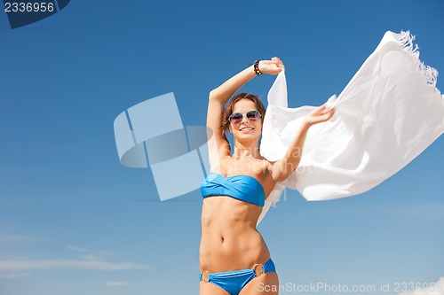 Image of happy woman with white sarong on the beach