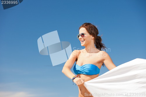 Image of happy woman with white sarong on the beach