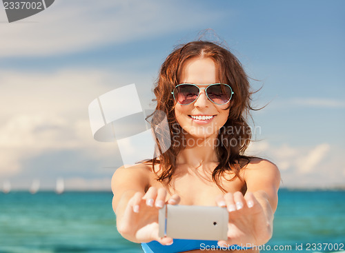 Image of happy smiling woman using phone camera