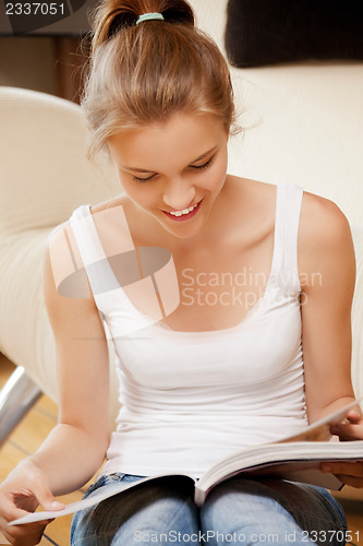 Image of happy and smiling teenage girl with magazine