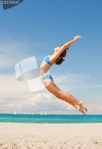Image of happy jumping woman on the beach