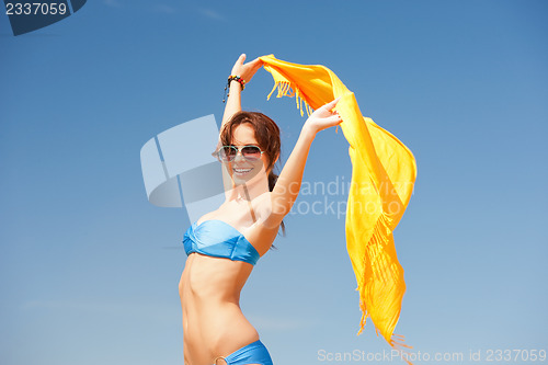 Image of happy woman with yellow sarong on the beach