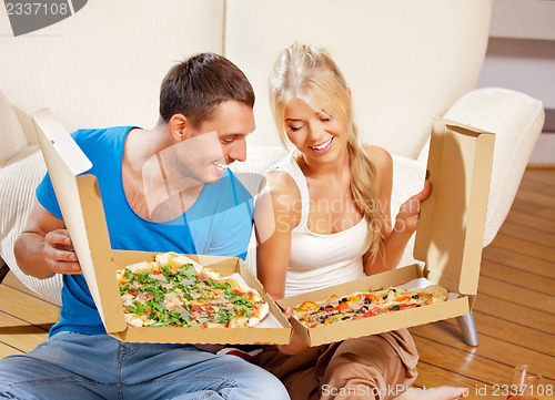 Image of romantic couple eating pizza at home