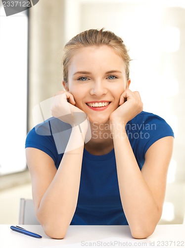 Image of happy teenage girl with pen and paper