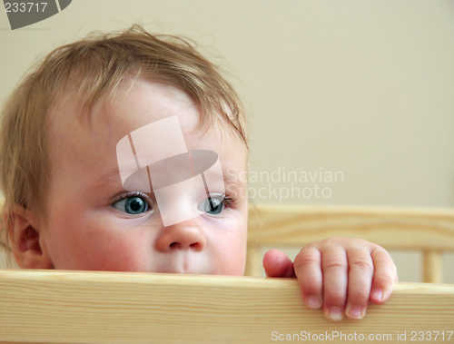 Image of baby looking from his bed