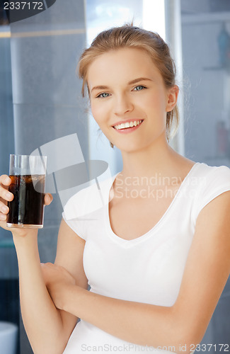 Image of happy and smiling teenage girl with glass of cola