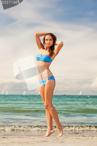 Image of happy smiling woman walking on the beach