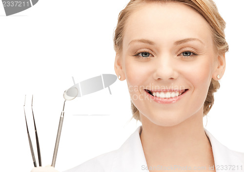 Image of attractive female dentist with tools