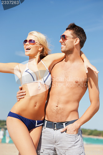 Image of happy couple in sunglasses on the beach