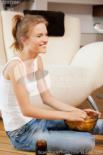 Image of smiling teenage girl with chips and coke