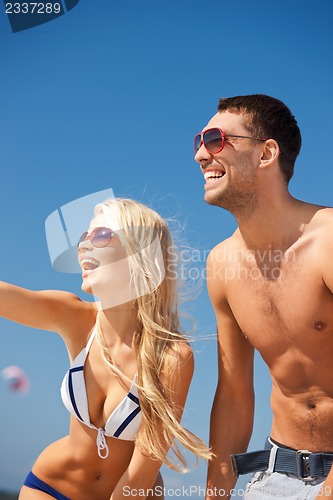 Image of happy couple in sunglasses on the beach