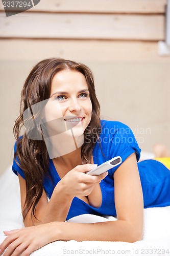 Image of happy woman with TV remote