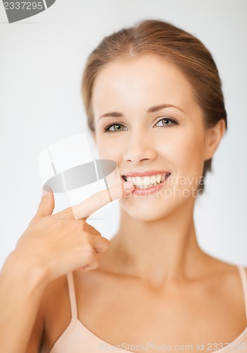Image of beautiful woman pointing to teeth