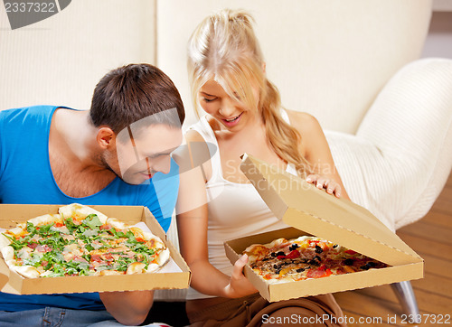 Image of romantic couple eating pizza at home