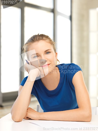 Image of happy teenage girl with pen and paper