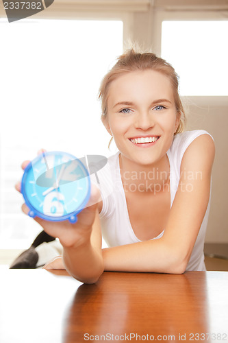 Image of happy and smiling teenage girl with clock