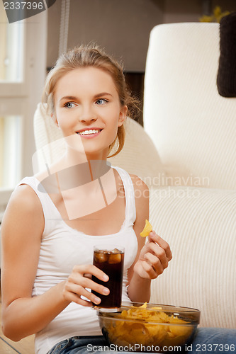 Image of smiling teenage girl with chips and coke