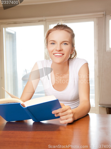 Image of happy and smiling teenage girl with book