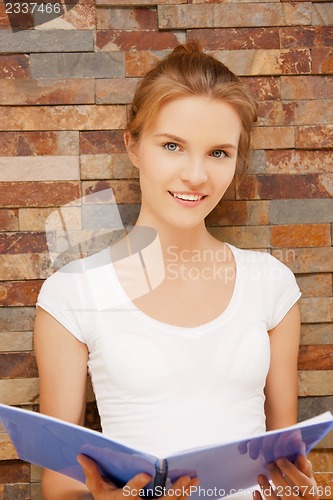 Image of happy and smiling teenage girl with big notepad