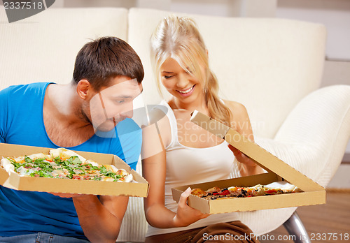Image of romantic couple eating pizza at home