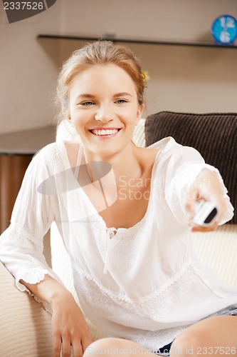 Image of happy teenage girl with TV remote
