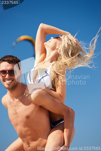 Image of happy couple in sunglasses on the beach